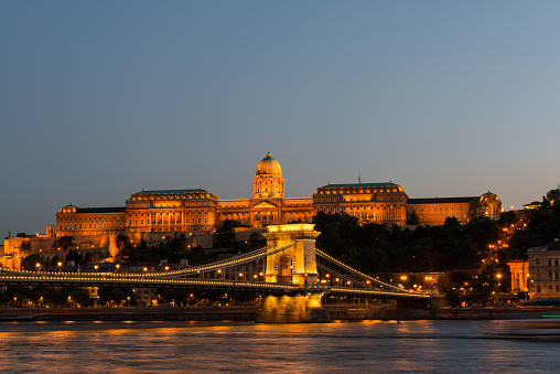 Night view of some of the most famous Hungarian landmarks, including the Széchenyi Chain Bridge and the Royal Palace as seen from the other side of the Danube river. Long Exposure.