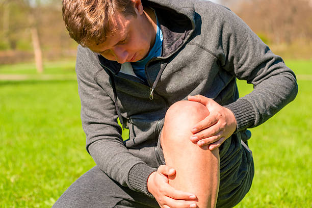 porträt eines mannes sitzen sein verletzte bein - pain the human body physical therapy human joint stock-fotos und bilder