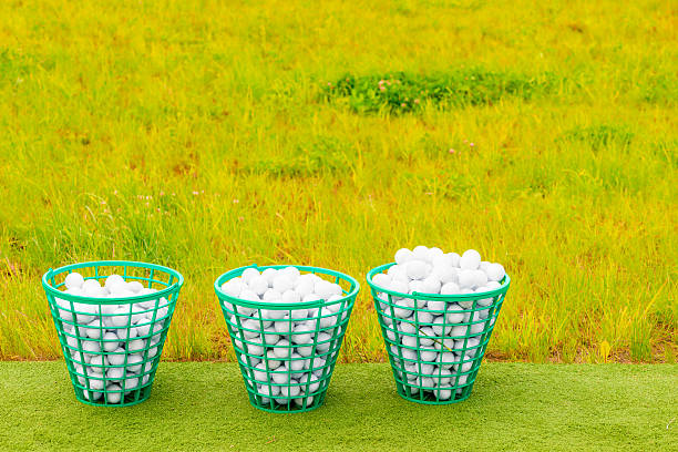 three baskets filled with golf balls on the green grass