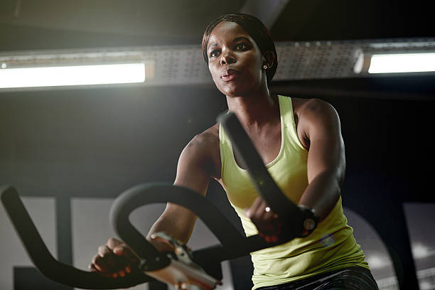 多くの��カロリーの燃焼サイクリング - gym women inside of exercising ストックフォトと画像