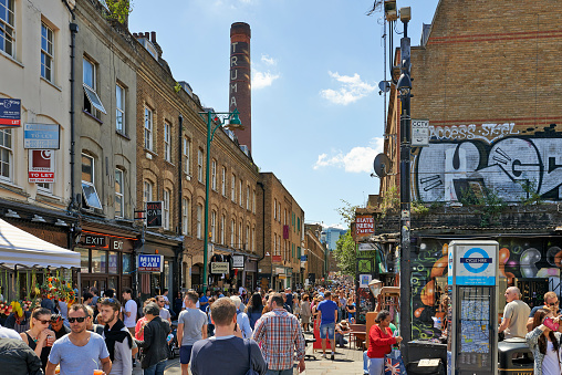 London,United Kingdom - June 08, 2014: People walking in Brick Lane street that's situated in brick Lane district, East part London, on a busy sunny Sunday