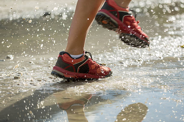 istock Sports shoes running stepping into puddle 484707790