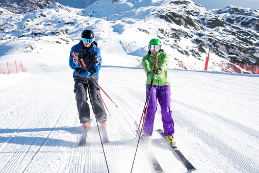 Man and woman skiing and enjoying during ski holiday.