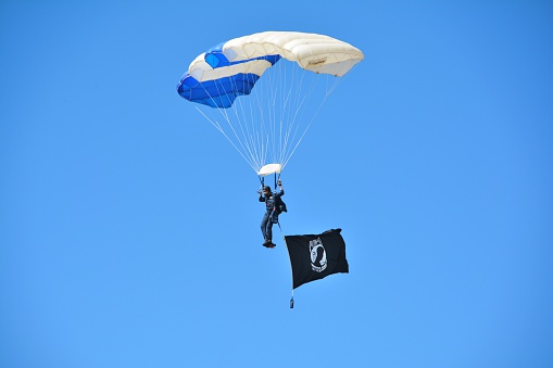 Broomfield, CO, USA - August 15, 2015: Skydiver with MIA Flag coming in for a landing at the Rocky Mountain Airshow.