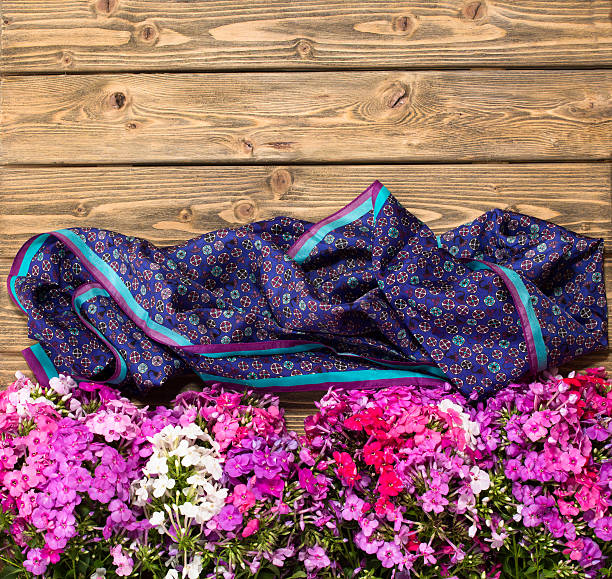 Wooden background with lilac flowers and violet neckcloth. The top space of background may be used for picture of the family.