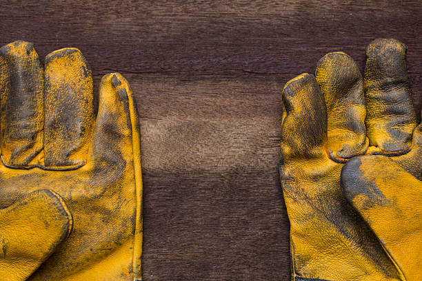 istock old dirty leather work gloves on wood background 484715728