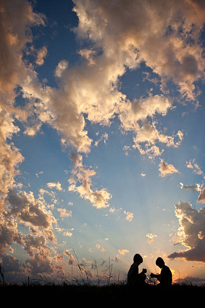 istock Silhouette of Two Children Praying 484716375