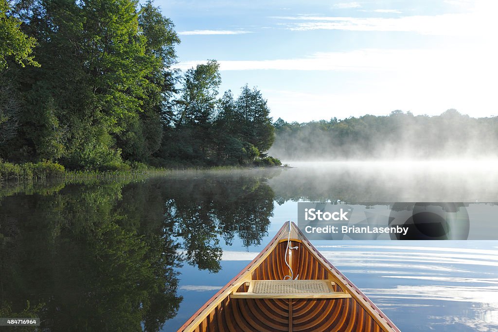 Cedar Canoe Bow on a Misty Lake Cedar Canoe Bow on a Misty Lake - Haliburton, Ontario, Canada Summer Stock Photo