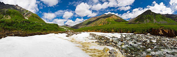 Summer panoramic view with river and snow in Sayan Mountains. stock photo