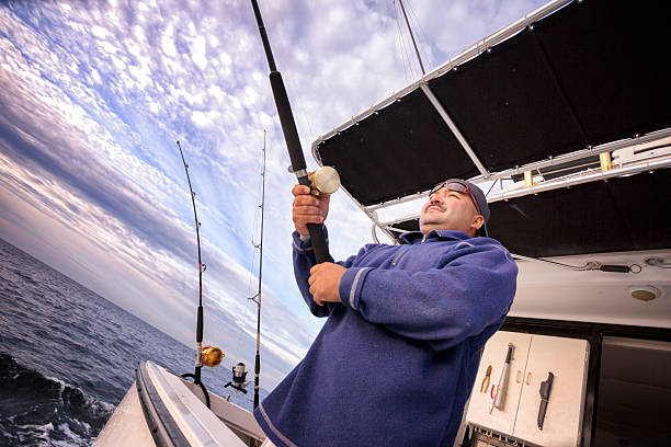 istock Young Hispanic Fisherman Catching a Big Fish on a Boat 484719177