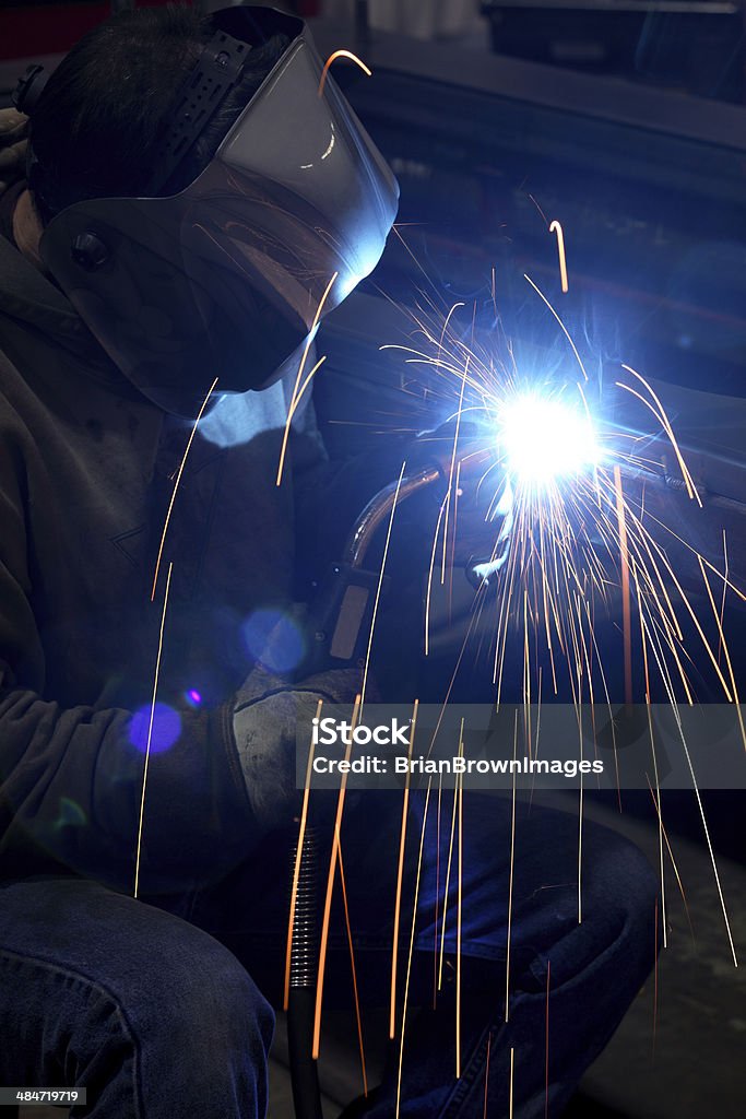 Welder Sparks fly as a  welder welds two pieces of metal together Animal Tricks Stock Photo