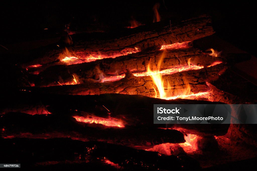 Campfire burning very hot with flames between the logs This campfire is very hot with flames between the logs,  Flames wrap around the logs and you can see the almost white hot center of the fire. 2015 Stock Photo