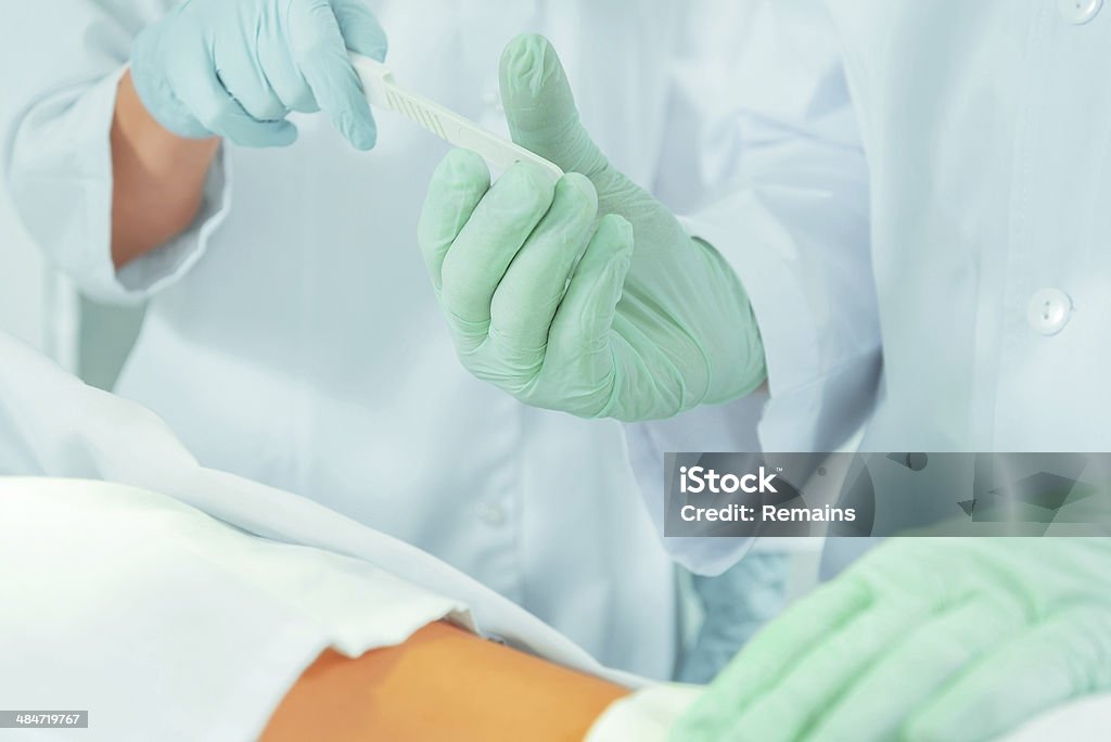 Assistant passes a scalpel Nurse assistant passes a scalpel to surgeon on operation Adult Stock Photo