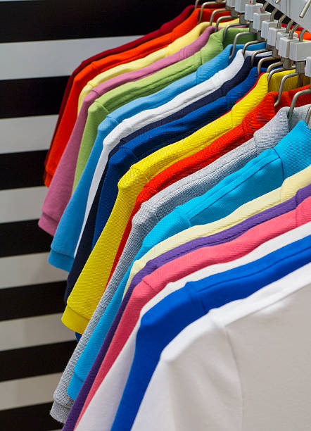 polo-shirts auf dem kleiderbügel - polo shirt multi colored clothing variation stock-fotos und bilder