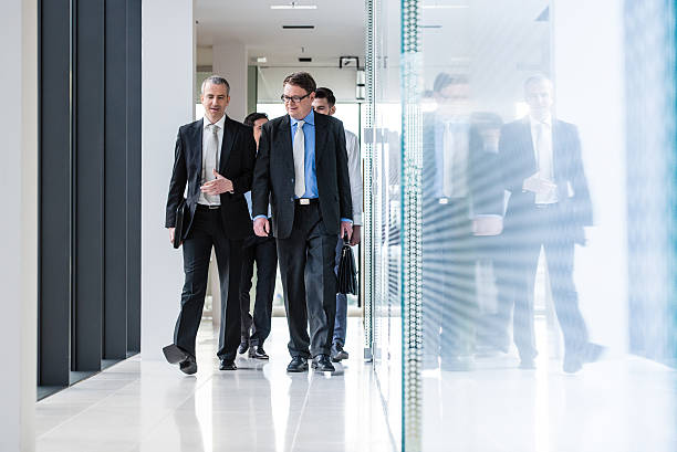 istock Businesspeople walking through office corridor 484721924