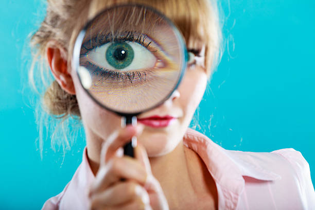istock Woman hand holding magnifying glass on eye 484724740