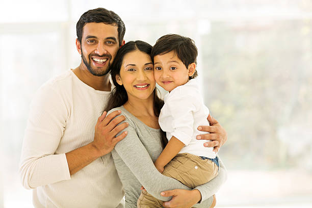 indian family of three portrait of happy indian family of three standing indoors happy indian young family couple stock pictures, royalty-free photos & images