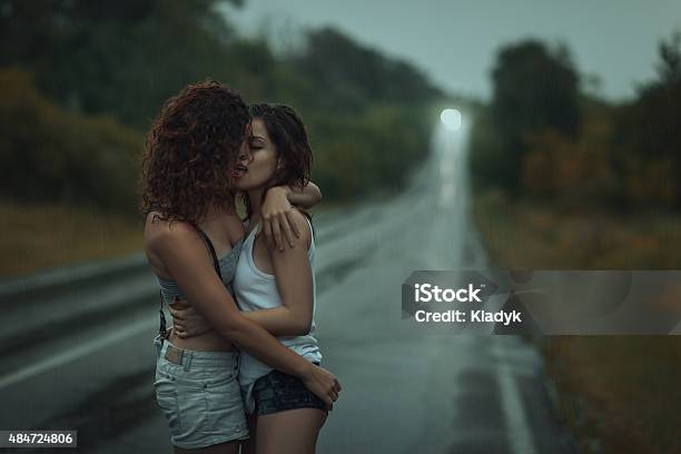 Girls Lesbians Kissing Under The Heavy Rain Stock Photo - Download Image Now - Rain, Kissing, Gay Couple