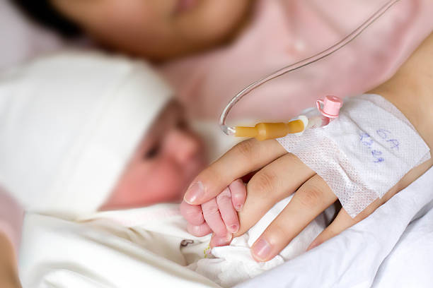 istock newborn and mom hand in hand holding 484728016