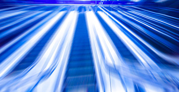 istock escalator on train station, view in blue tone.motion blur 484732652