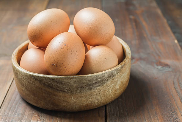 istock Fresh eggs in wood bowl on wood background 484733672