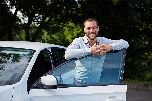 Handsome man leaning on car door