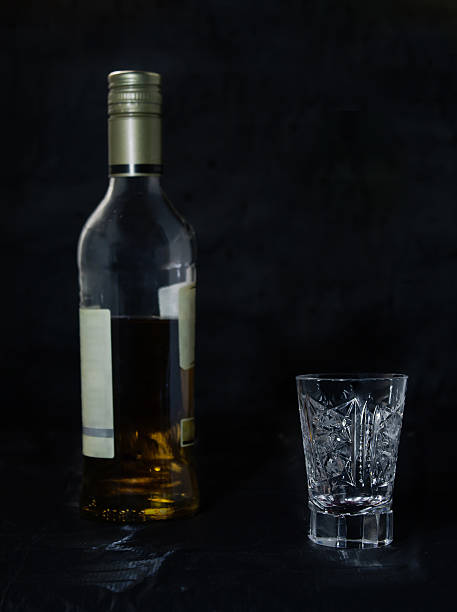 istock Bottle of whiskey and a glass on a black background. 484738530