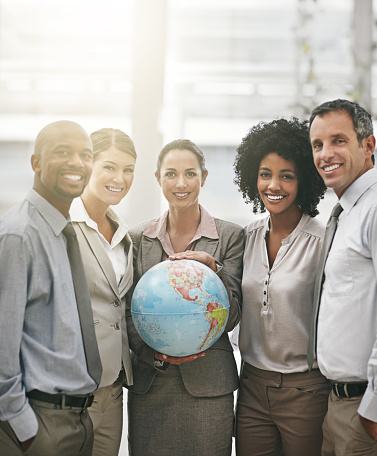 Cropped portrait of a businesswoman holding a globe while standing with her colleagueshttp://195.154.178.81/DATA/i_collage/pu/shoots/805421.jpg