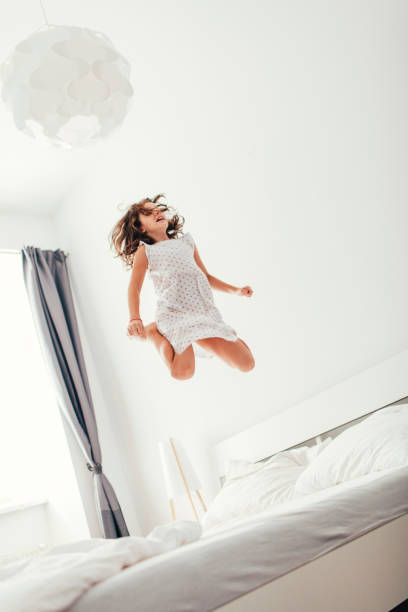 istock Little Girl Jumping On The Bed. 484742324