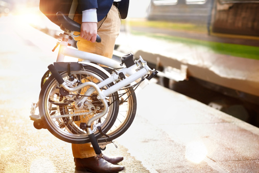 Empresario con asiento plegable bicicleta en la plataforma de tren photo