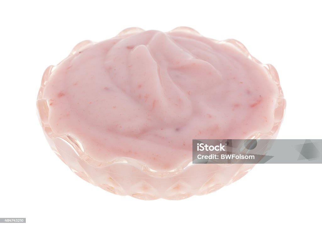 Glass bowl filled with strawberry yogurt A small crystal glass bowl filled with a serving of strawberry yogurt on a white background. 2015 Stock Photo