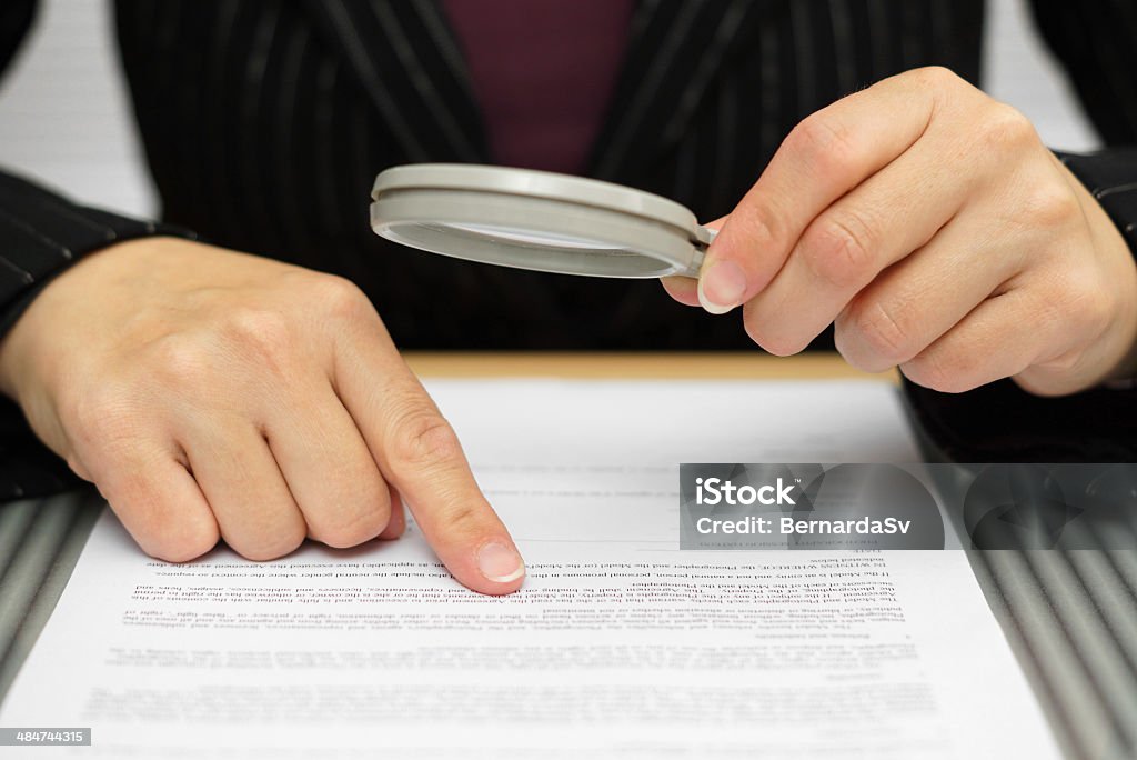 Femme d'affaires regardant à travers une loupe pour le contrat - Photo de Contrat libre de droits