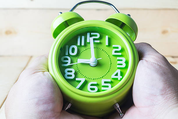 istock Hand hold Green alarm clock on wood background 484744666