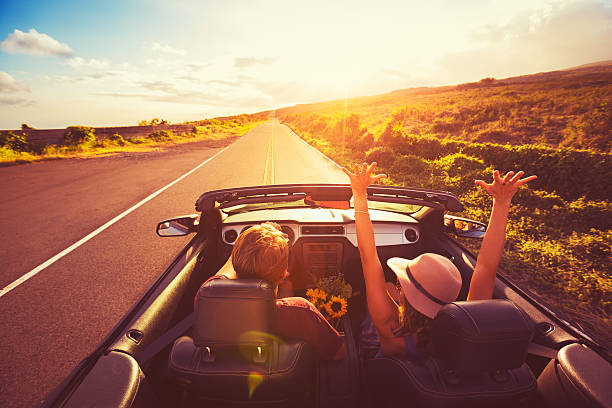 Couple Driving Convertable at Sunset Happy Young Couple Driving Along Country Road in Convertable at Sunset. Freedom Adevnture Roadtrip! domestic car photos stock pictures, royalty-free photos & images