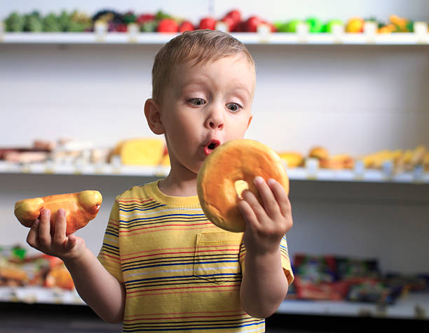 donut or croissant - jongen peuter eten stockfoto's en -beelden