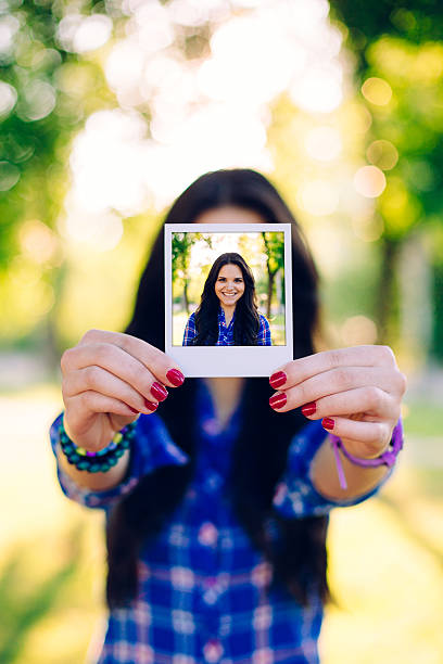 istock Girl holding instant photo 484745506