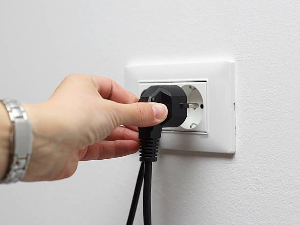 istock electricity savings concept, woman unplugged plug from the socket 484746115