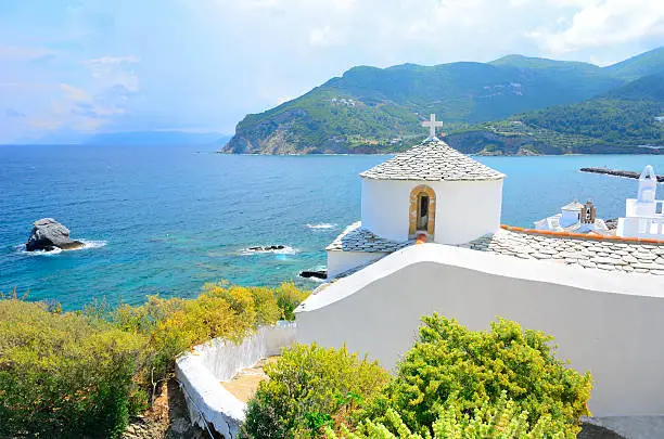 View on a monumental white church and incoming storm above Chora, Skopelos island, Sporades archipelageo, Greece