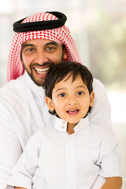 istock arabian father and son sitting at home 484752256