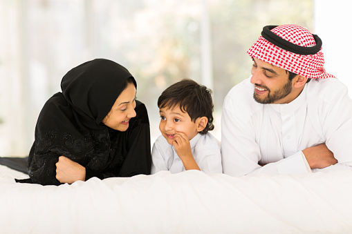 Jóvenes musulmanes family lying on bed photo
