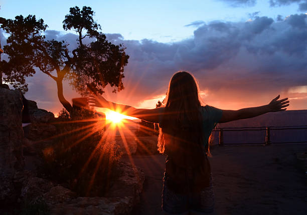 istock Girl catching sunlight at beautiful sunset. 484754372