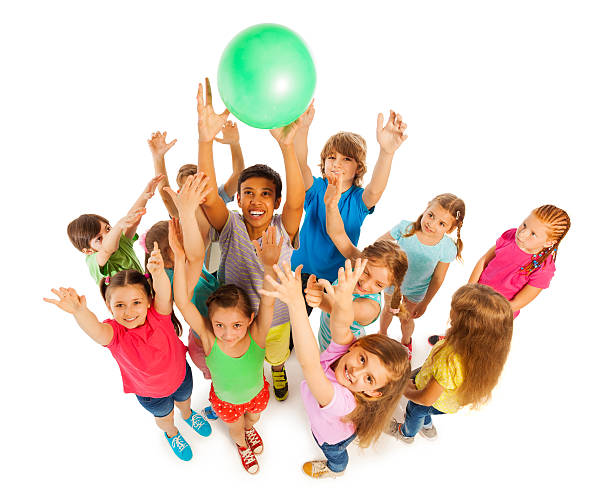 Group of kids catching green ball Group of kids playing ball shot from above isolated on white child holding ball stock pictures, royalty-free photos & images