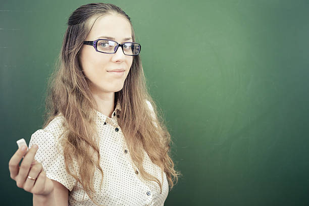 istock teacher or student, holding a chalk near green chalkboard 484758958