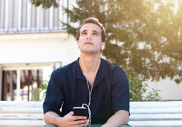 istock Man with mobile phone and earphones looking up 484762130