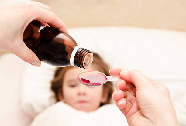 istock Mother pouring medication in a spoon 484762397