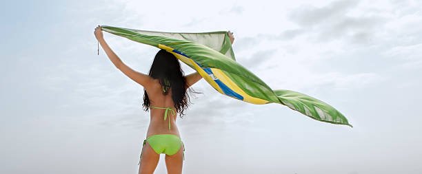young beautiful girl holding brazil flag into the wind stock photo