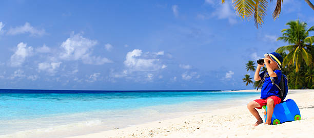 istock little boy travel on summer tropical beach with suitcase 484762746