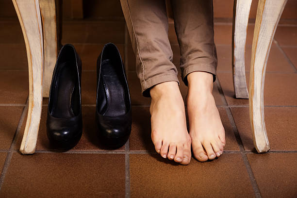 istock Bare female feet under the vintage table. 484762826