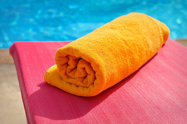 istock folded orange towel on the background of the pool 484764369