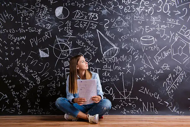 Photo of Beautiful young girl in front of blackboard